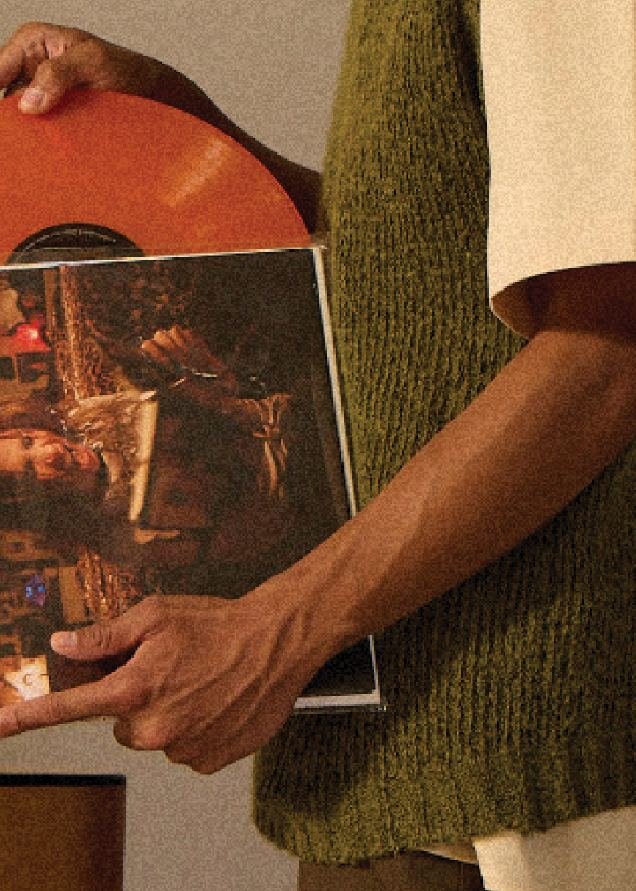 Person holding a vinyl record and its sleeve