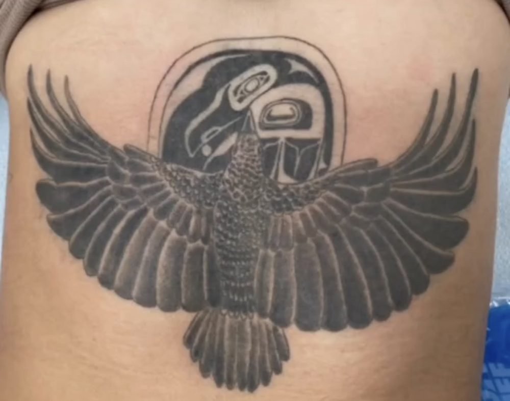 Large black winged chest tattoo before treatment